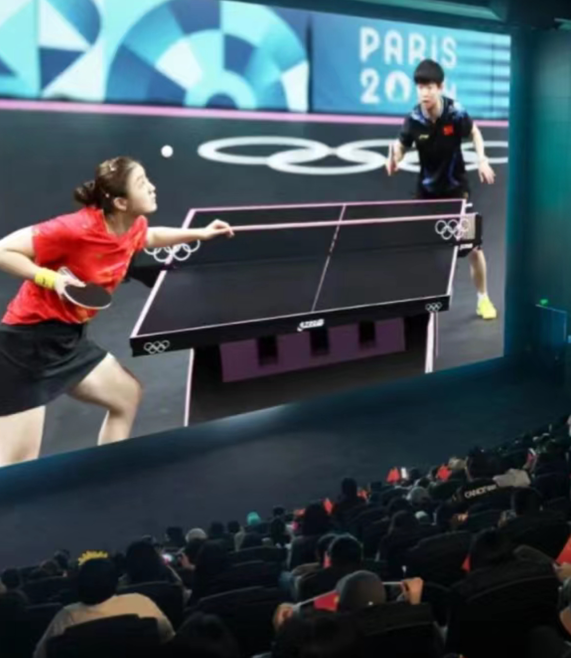 Chinese spectators watch ping pong at a cinema.